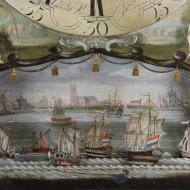 Staand horloge van 'Gerrit Vos, Amsterdam', met scheepsmechaniek en vissertje onder de cijferring.