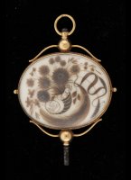Antieke gouden zakhorloge sleutel met aan beide zijden een decoratie van menselijk haar, waarschijnlijk van een overleden dierbare.

maten: 65 x 45 mm